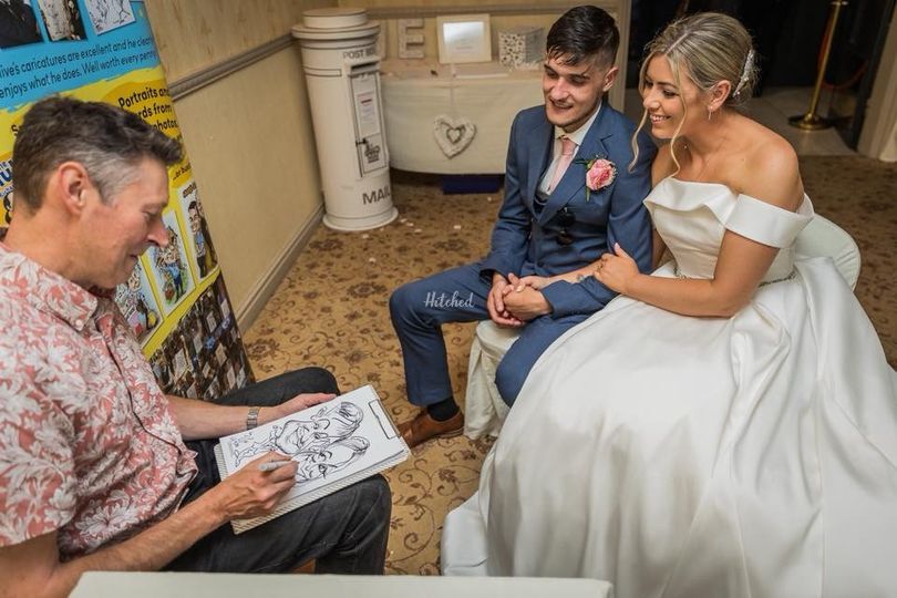 Live wedding caricature service, artist sketching a smiling bride and groom in warm indoor light, elegant reception atmosphere.