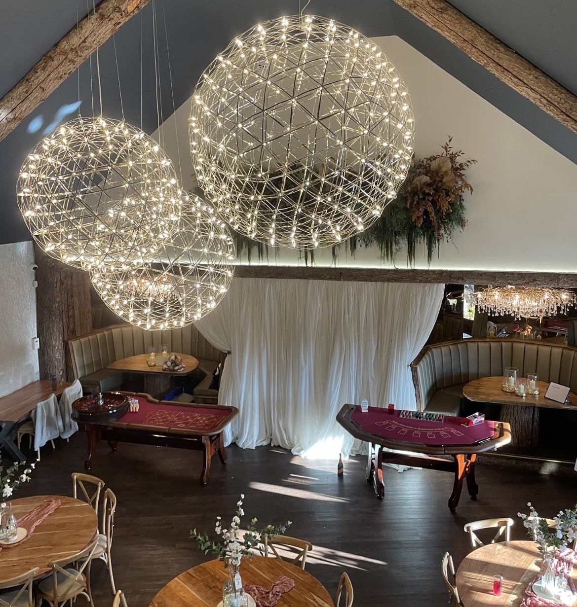 A polished wooden roulette table features a rich red felt surface, surrounded by elegant decor and soft ambient lighting, creating a sophisticated atmosphere.