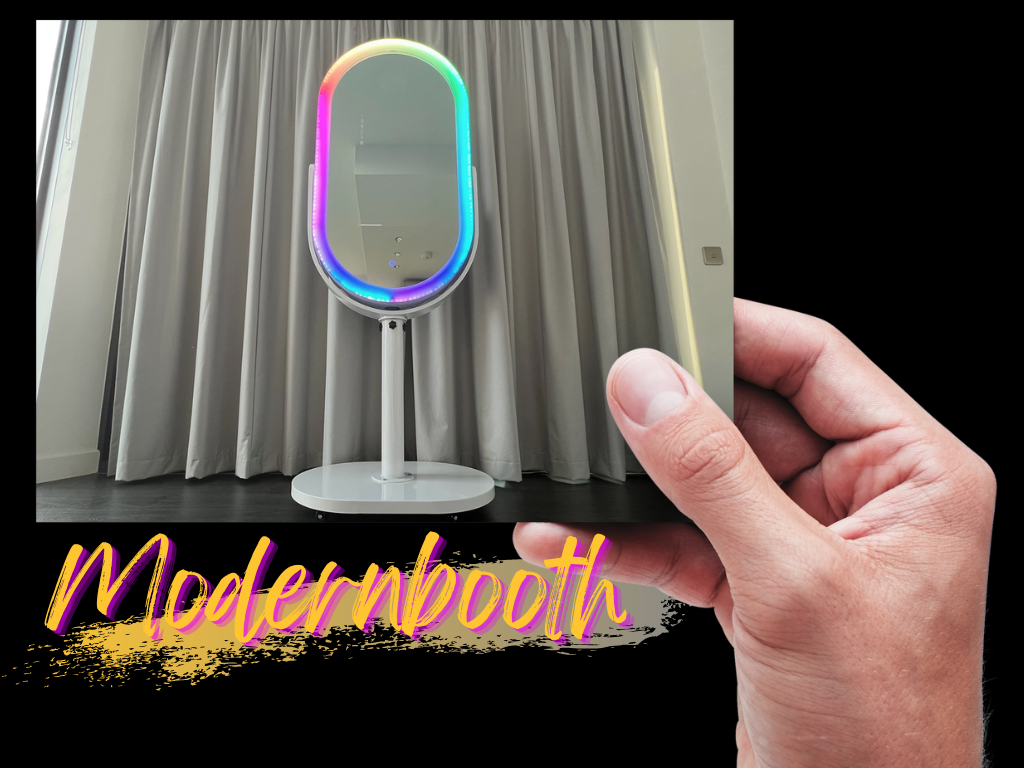 A sleek, oval mirror with colorful LED lighting stands on a white base, set against soft grey drapes, creating a modern and inviting atmosphere.
