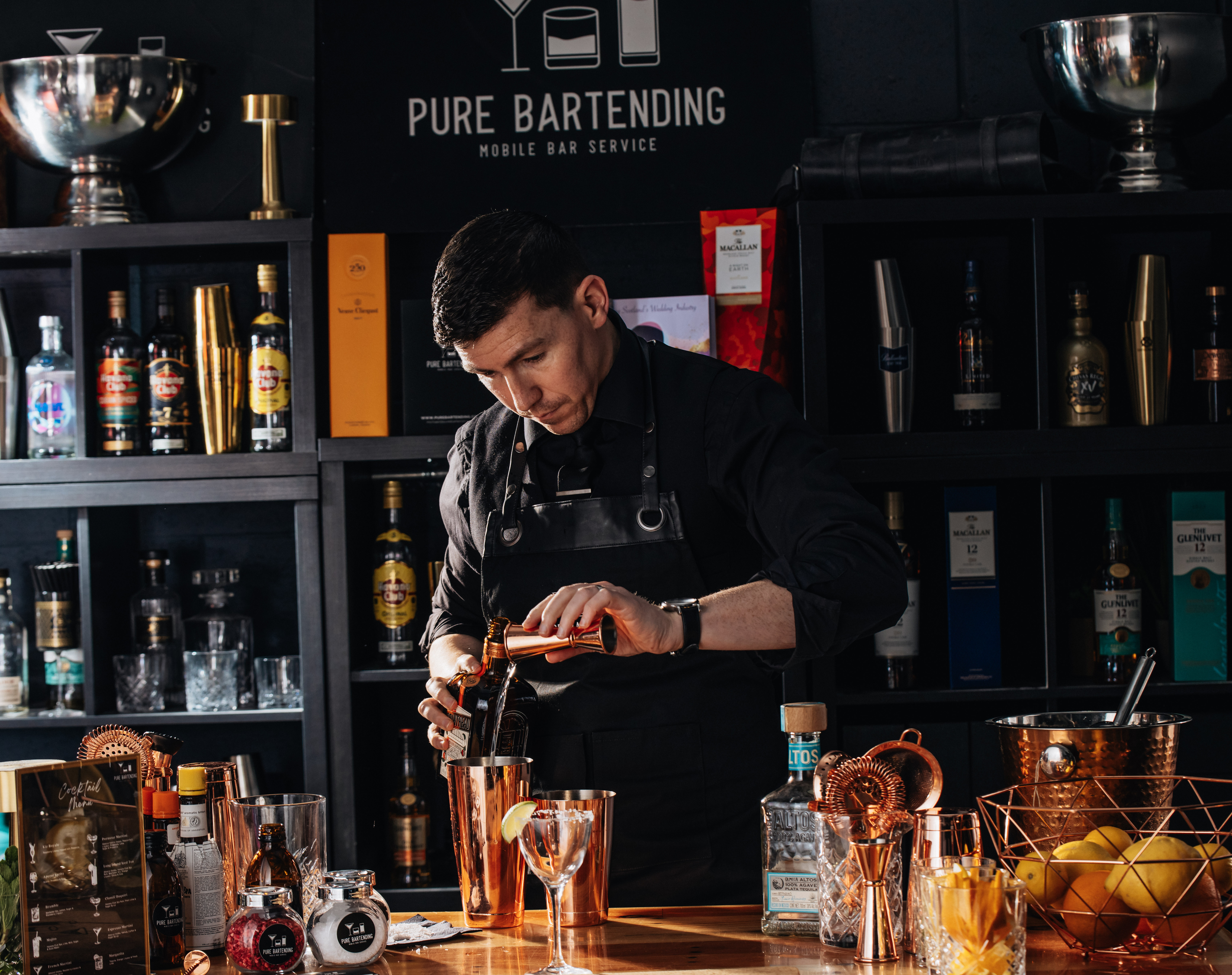 A polished, modern bar showcases a stylish cocktail in a crystal glass, complemented by gleaming copper shakers, amidst a warm, intimate atmosphere.
