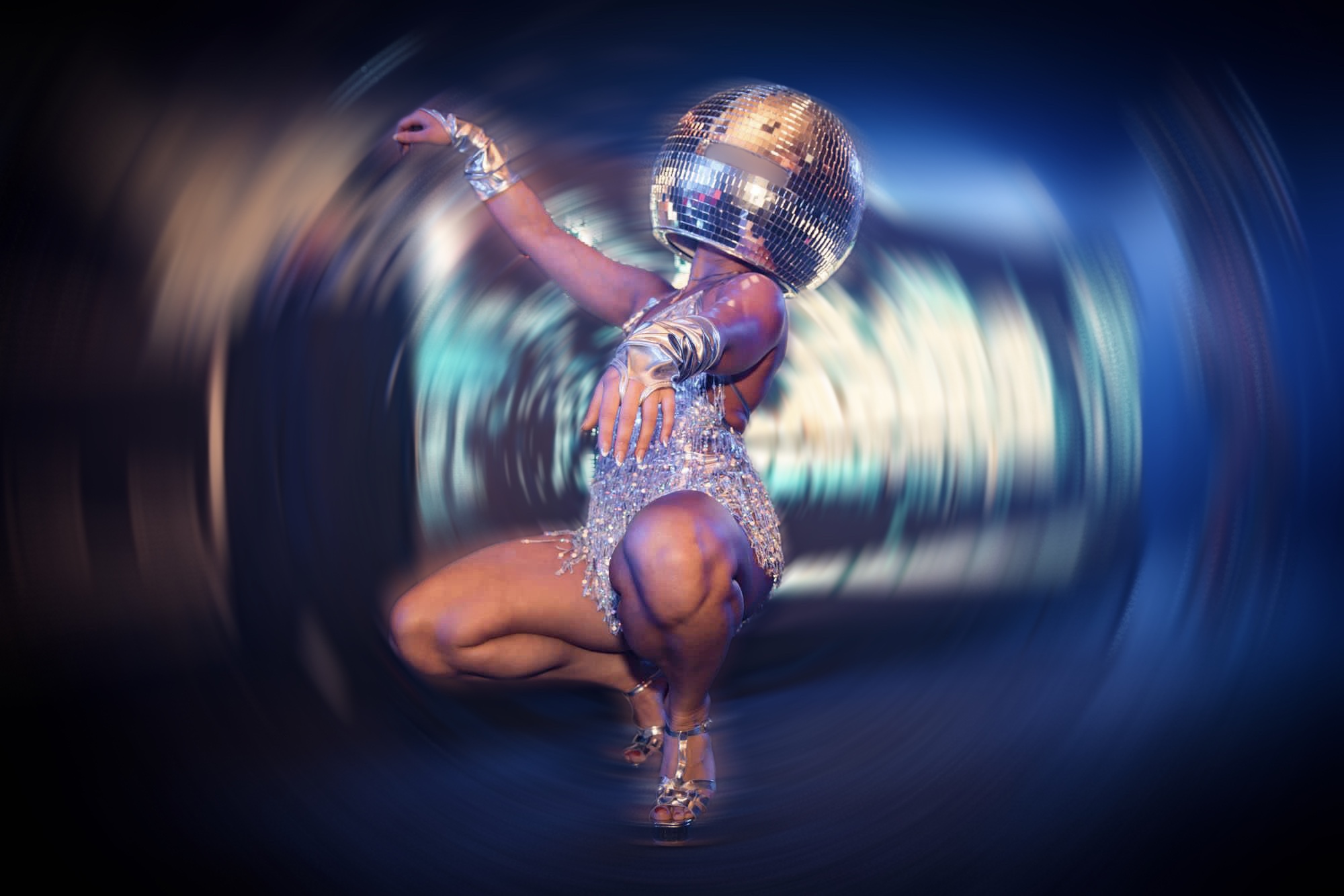 A performer in a sparkling silver outfit and a disco ball helmet strikes a dynamic pose, set against a vibrant blue backdrop, creating a lively atmosphere.