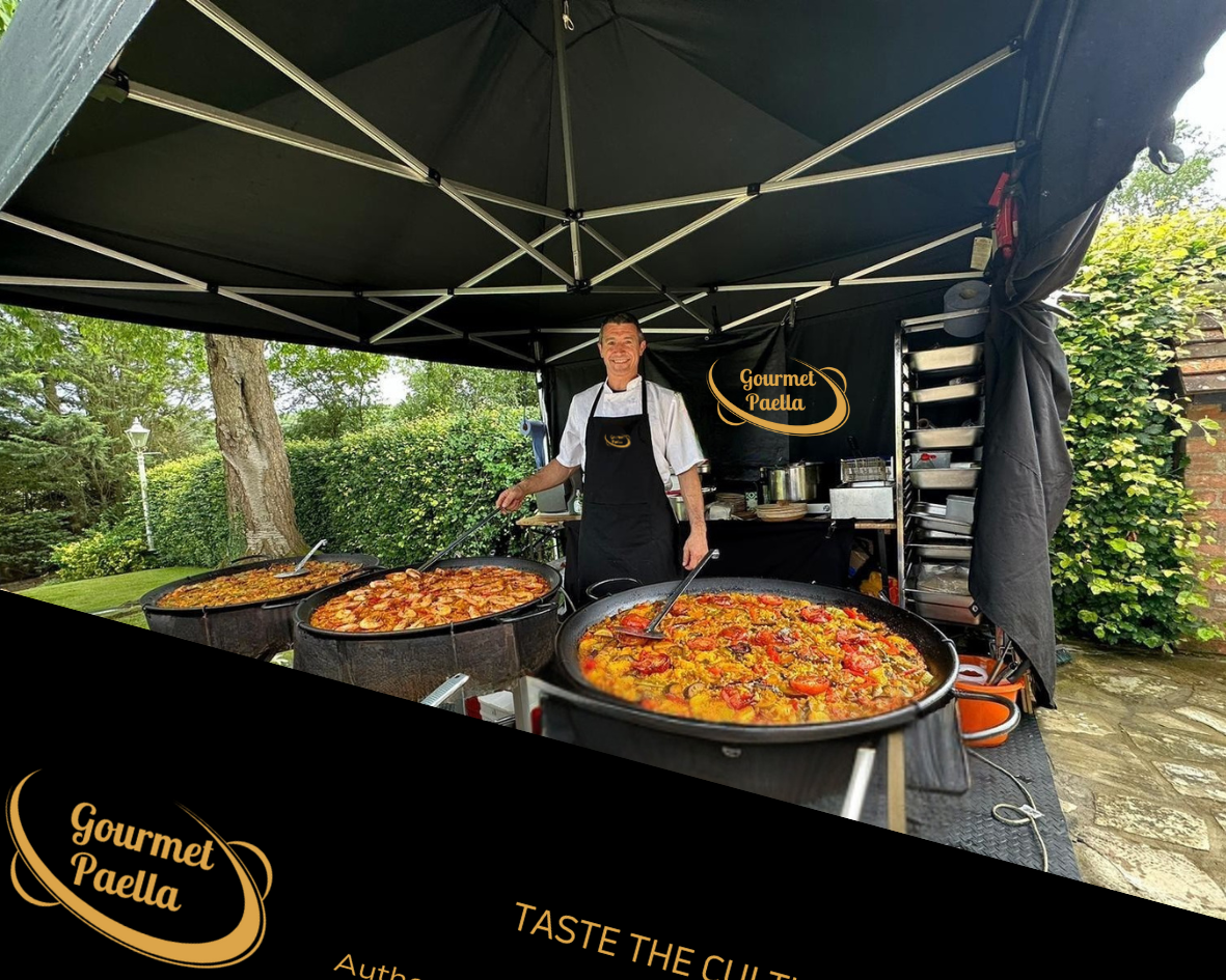 Under soft daylight, a smiling chef stands beside three large black pans of vibrant, seasoned paella, showcasing exquisite catering quality.