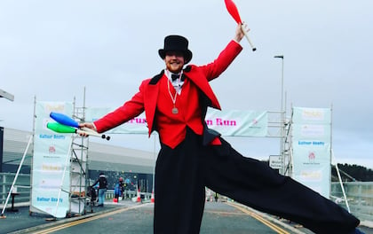 Stilt-Walking Ring Master Welcomes Guests with Juggling Spectacle