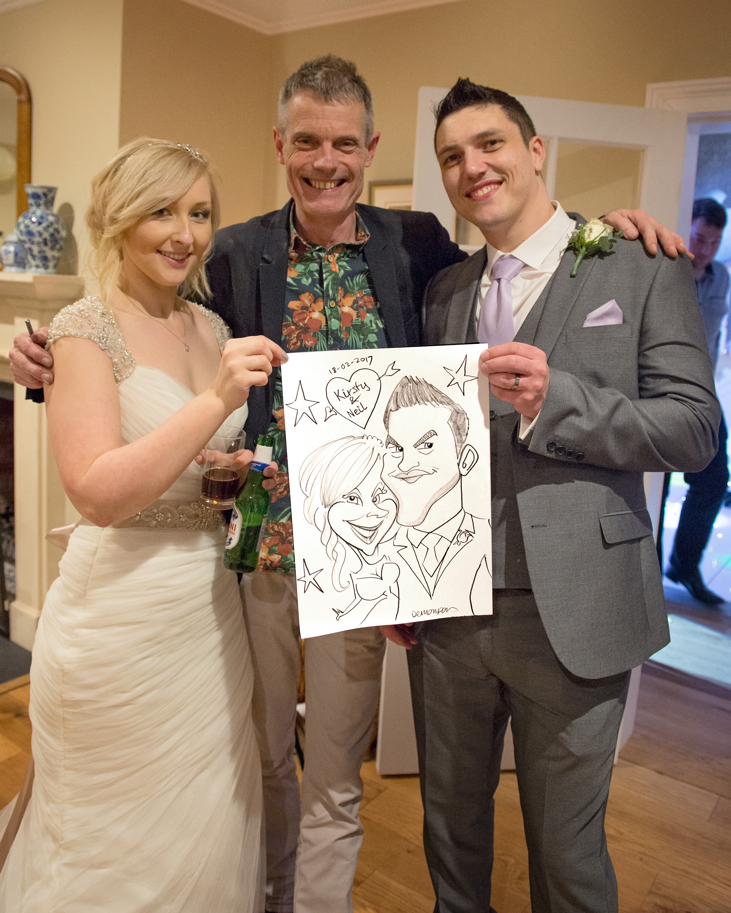 A joyous wedding scene features a bride in a flowing white gown, a groom in grey suit, and a caricaturist showcasing playful artwork, enhancing the celebratory mood.