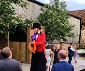 Stilt-Walking Ring Master Welcomes Guests with Juggling Spectacle