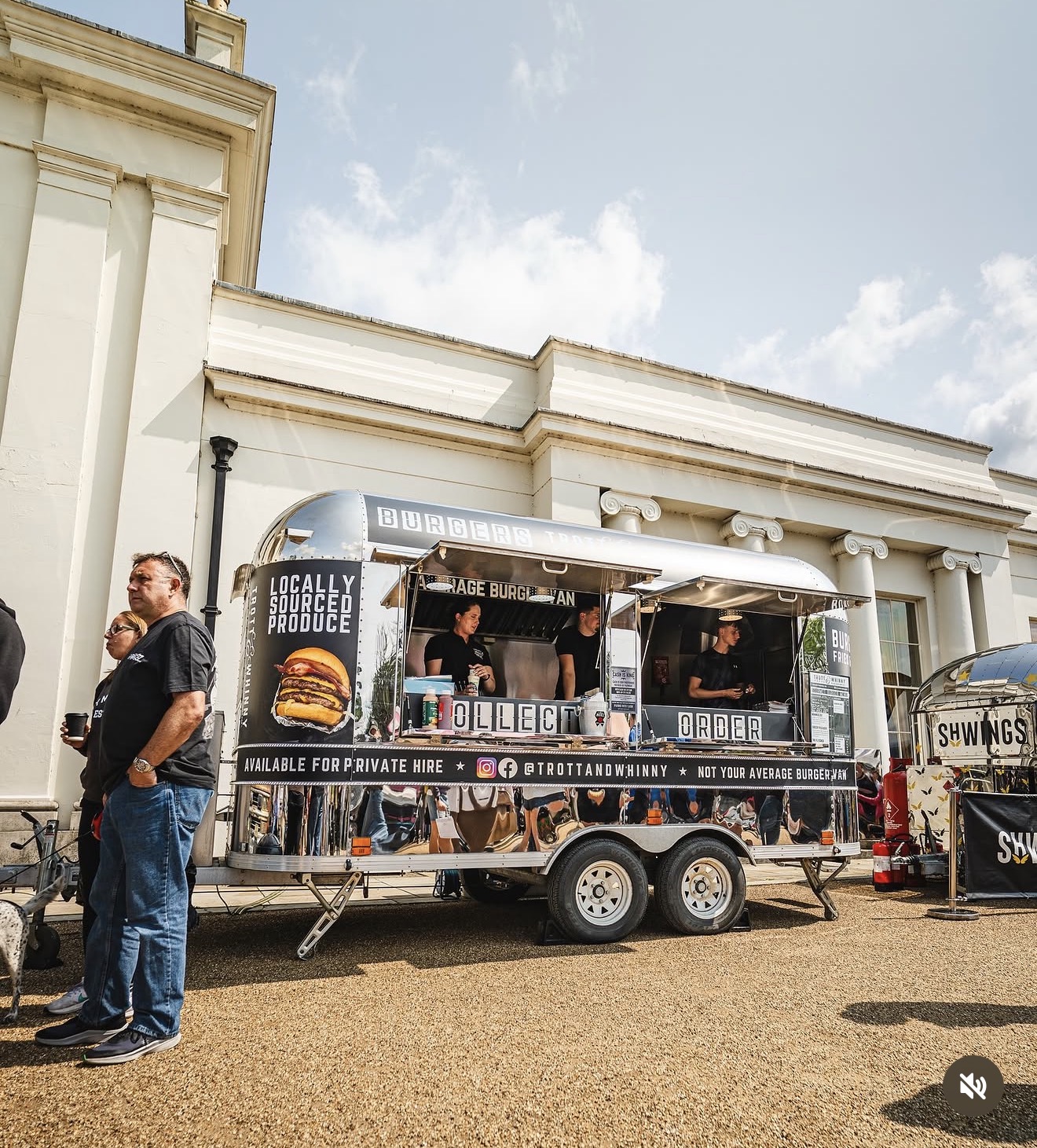 A shiny silver food truck features a vibrant burger menu, surrounded by a bright, sunny outdoor setting, showcasing local produce and friendly service.